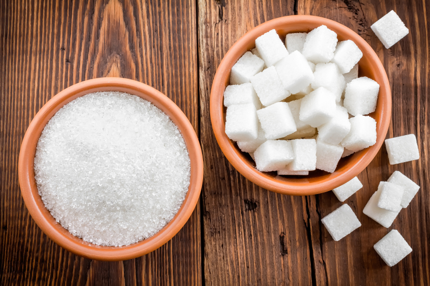 one bowl of sugar granules, one of sugar cubes