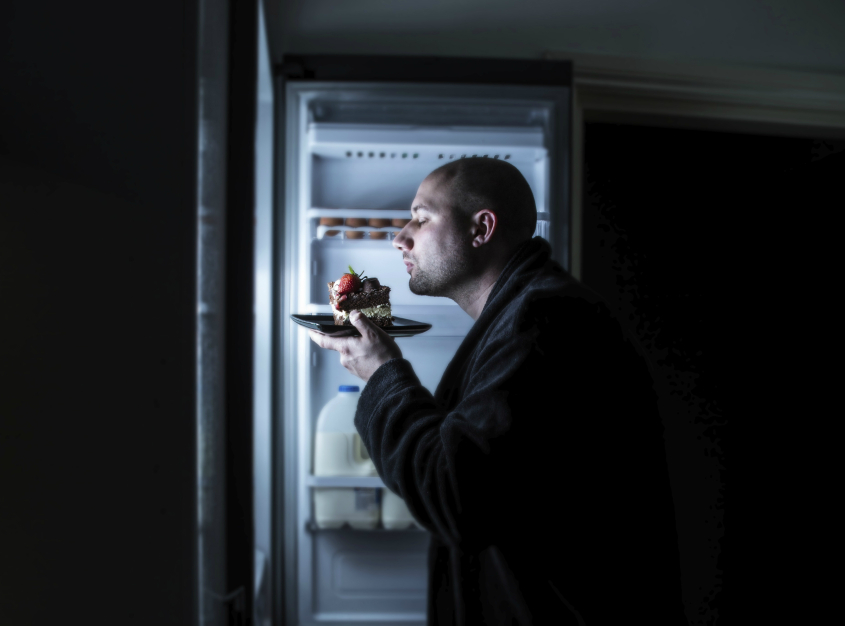 Man snacking from fridge at nighttime