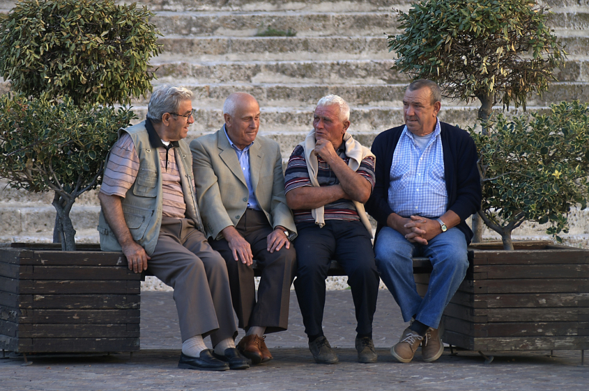 Four elderly men sitting on a bench