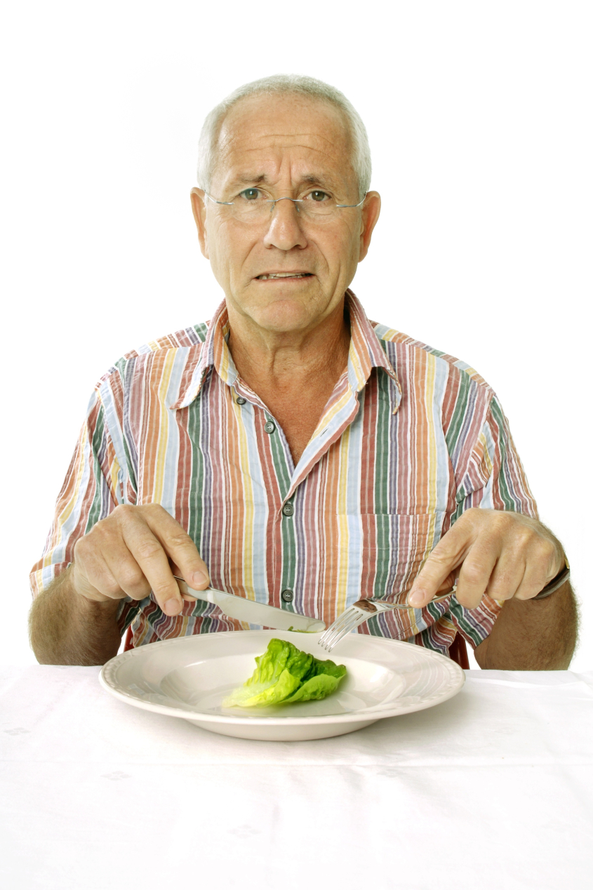 Elderly man eating lettuce